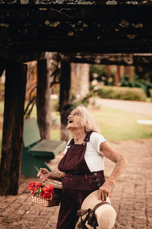 A happy grandmother on the sidewalk with a flower basket