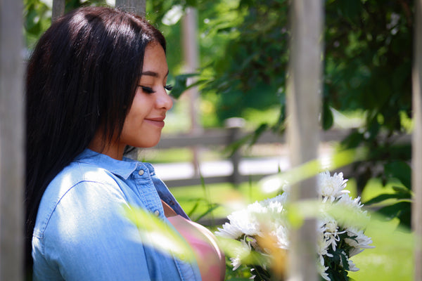 A smiling, relaxed woman in a green garden