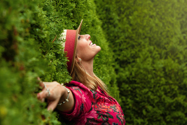 A happy, smiling woman laying on the green grass looking upward